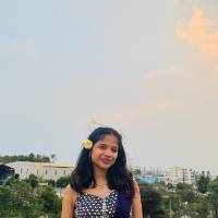 Woman standing in front of beachy background smiling